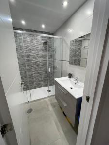 biała łazienka z prysznicem i umywalką w obiekcie Duplex RiAnna w Costa Teguise