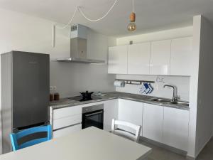 kuchnia z białymi szafkami oraz białym stołem i krzesłami w obiekcie Duplex RiAnna w Costa Teguise