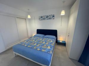 sypialnia z łóżkiem z niebieską kołdrą i 2 światłami w obiekcie Duplex RiAnna w Costa Teguise +20 zdjęć