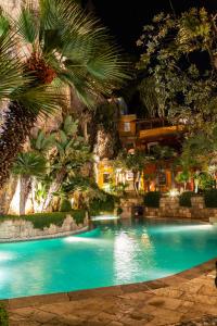 una piscina en un complejo con palmeras en Aeneas' Landing Resort, en Gaeta