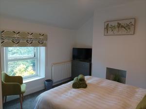 un osito de peluche sentado en una cama en un dormitorio en Victorian Renovation Room 5, en Liverpool