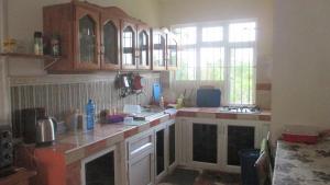 a kitchen with wooden cabinets and a counter top at Villa GRAND BAIE LA CROISETTE in Grand Baie