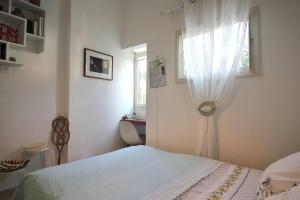 biała sypialnia z łóżkiem i oknem w obiekcie Charming 2-Bedroom Apartment in Basel Square by HolyGuest w Tel Awiwie