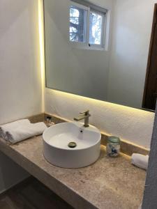 uma casa de banho com um lavatório branco e um espelho. em Lila Hotel em Atotonilco