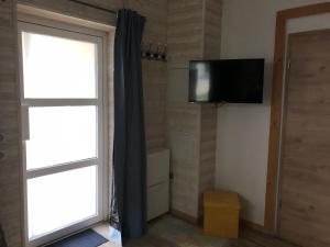 Zimmer mit einem Fenster und einem TV an der Wand in der Unterkunft Le Cottage du Vieux Moulin in Ravilloles