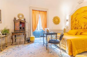 a bedroom with a large bed and a desk and chairs at Il Moresco Catania in Catania