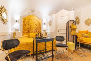 a bedroom with a yellow bed and two chairs at Il Moresco Catania in Catania