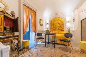 a bedroom with a yellow bed and a table and chairs at Il Moresco Catania in Catania