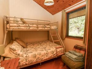 1 dormitorio con 2 literas y mesa en Firbush Lodge, en Killin