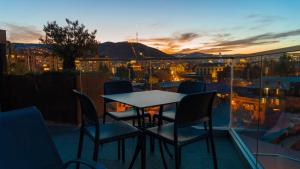 einen Tisch und Stühle auf einem Balkon mit Stadtblick in der Unterkunft Hotel Banovani in Tbilisi City