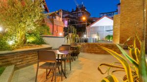 a patio with a table and chairs and a building at Hotel Banovani in Tbilisi City