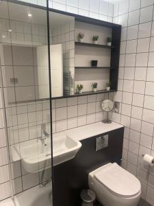 a bathroom with a sink and a toilet and a mirror at Stylish Birmingham City Centre Apartment in Birmingham