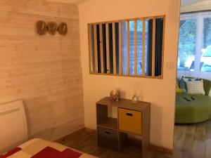 una stanza con tavolo e specchio sul muro di Le Cottage du Vieux Moulin a Ravilloles