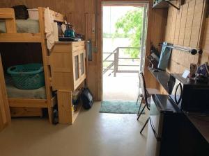 een kamer met een stapelbed en een deur naar een veranda bij Wilderness Roost on Lake Godstone in Jacksboro