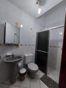 La salle de bains est pourvue de toilettes, d'un lavabo et d'une douche. dans l'établissement Pousada Clara Manhã, à Bombinhas