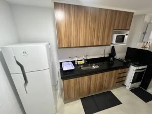 Una cocina con un refrigerador blanco y un fregadero. en Residence club Praia dos Anjos, en Arraial do Cabo
