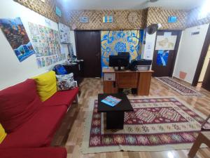 a living room with a red couch and a tv at Hakaia Community in Aqaba +15 photos