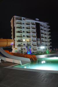 un gran edificio de apartamentos por la noche con piscina en Sea View Studio in Orion Garden en Avsallar