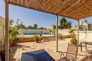 un patio con mesa y sillas en la azotea en Millennium Inn Mendoza en Mendoza