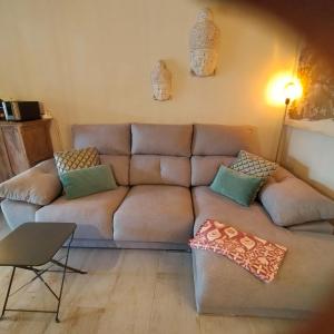 a living room with a brown couch with pillows at Casa Francesca Altea piscina y aparcamiento privado in Altea