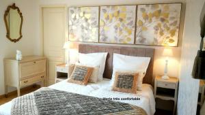 Un dormitorio con una cama con almohadas y una pintura en Charme Le Cadran Solaire classé 4*, en Sancey-le-Long