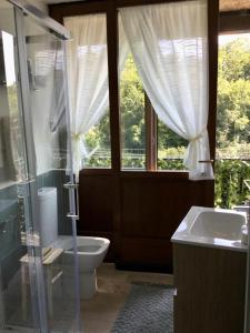 een badkamer met een toilet, een wastafel en een raam bij Rosmary42 in Bosco Chiesanuova