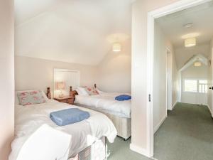 2 camas en una habitación con paredes blancas en Advantage Point en West Lulworth