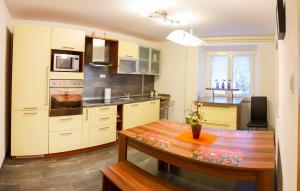 a kitchen with a wooden table and a dining room at Apartments Shock in Cerkno +5 photos