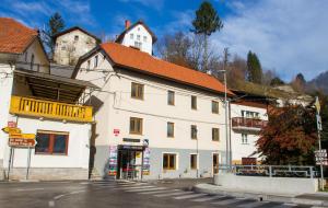 a white building with a red roof on a street at Apartments Shock in Cerkno