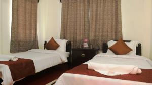 a hotel room with two beds and curtains at K & K INN in Cherrapunji