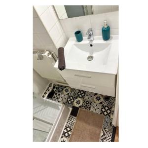 a bathroom with a white sink and a floor at T2 rénové avec parking gratuit sur place in Valence