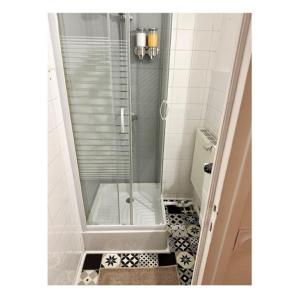 a shower with a glass door in a bathroom at T2 rénové avec parking gratuit sur place in Valence