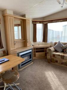 a living room with a couch and a table at Rejuven8 Rentals - Silver Beach - Ingoldmells - Skegness in Ingoldmells