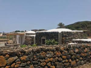 una casa in pietra con un muro di roccia di La Grotta di benikula' a Pantelleria