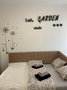 - une chambre avec un lit et un panneau mural dans l'établissement LITTLE GARDEN - self CHECK IN, à Osijek