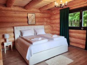 a bedroom with a bed in a log cabin at Harghita Log Houses in Izvoare