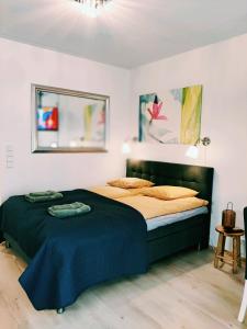 um quarto com uma cama grande e um cobertor azul em Joutjärven Studio Apartment em Lahti