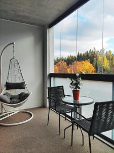Pokój z huśtawką, stołem i krzesłami w obiekcie Joutjärven Studio Apartment w mieście Lahti