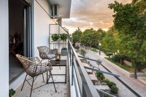 d'un balcon avec des chaises et une table offrant une vue sur la rue. dans l'établissement Eleusis Suites Β, à Elefsina