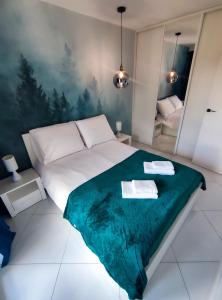 1 dormitorio con 1 cama con manta verde en Apartament Blue BB, en Bielsko-Biala