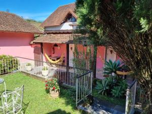 una casa con una valla y un patio con plantas en Pousada Lírio do Campo, en São Pedro da Serra
