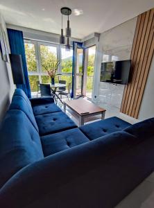 a blue couch in a living room with a table at Apartament Blue BB in Bielsko-Biala