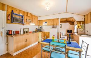 a kitchen with wooden cabinets and a table and chairs at Stunning Apartment In La Coquille in La Coquille
