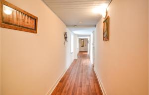 a hallway with white walls and wooden floors and paintings at Stunning Apartment In La Coquille in La Coquille