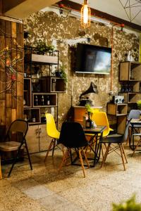 a room with chairs and a table and a tv at Panela Coffee Hostel in Medellín