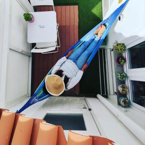 a man in a hammock on the back of a boat at Stressfree Apartamento in Vila Nova de Milfontes