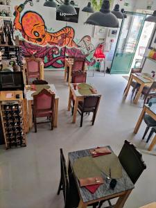 una tienda con mesas y sillas y un mural en Stressfree Apartamento, en Vila Nova de Milfontes