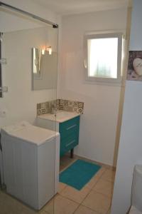 ein Bad mit einem Waschbecken und einem Spiegel in der Unterkunft Joli appartement au calme entre Nîmes et Avignon in Meynes