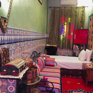 a bedroom with a bed and a table with a stove at ALMARKAB Riad in Marrakech