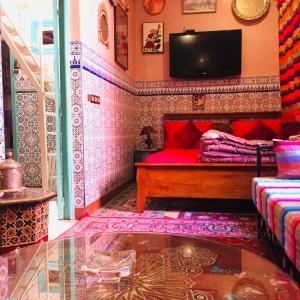 sala de estar con sofá rojo y TV en ALMARKAB Riad, en Marrakech